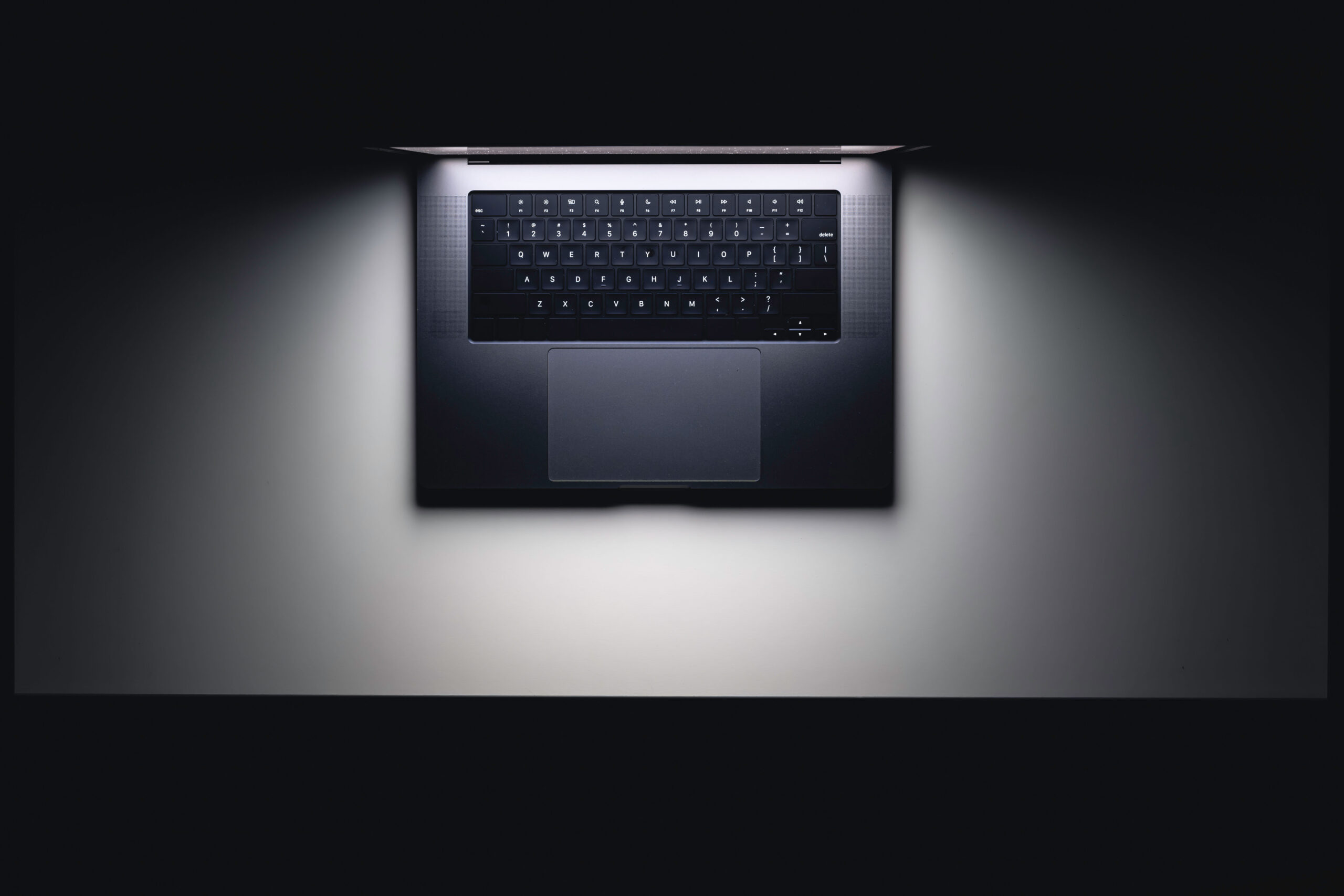 MacBook auf Tisch mit hellem, leuchtenden Bildschirm